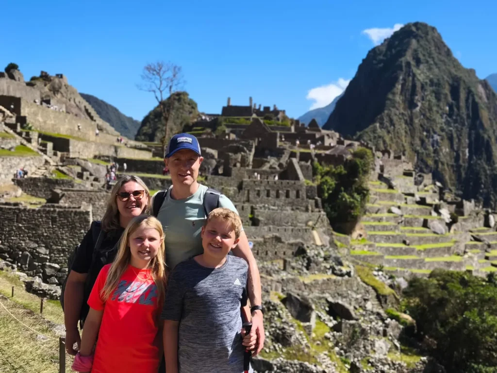 Tourists walking the agricultural terraces with a certified guide and citadel views in the background