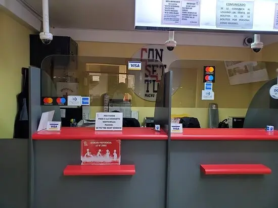 Traveler holding a Consettur ticket at the terminal entrance in Aguas Calientes