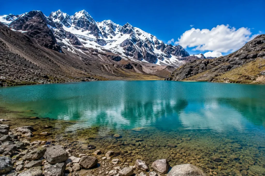 Turquoise lagoon on the Ausangate 7 Lakes circuit surrounded by snow-capped peaks