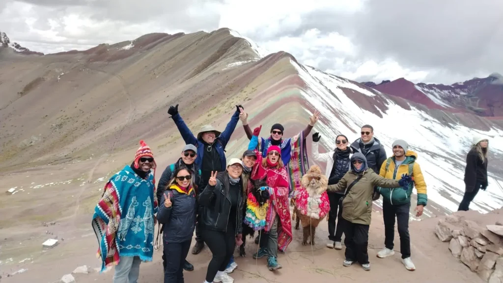 Hikers on the Rainbow Mountain tour walking toward the colorful striped peaks of Vinicunca